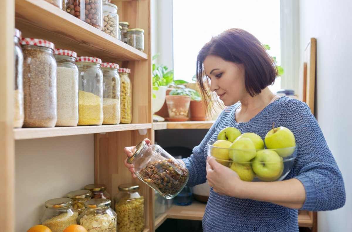 Mulher escolhendo alimentos da despensa
