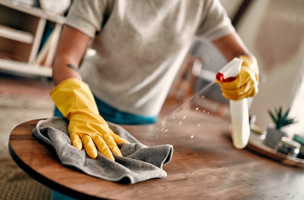 Mãos ressecadas e envelhecidas? Confira essas dicas! - Pessoa usando luvas para fazer a limpeza da casa